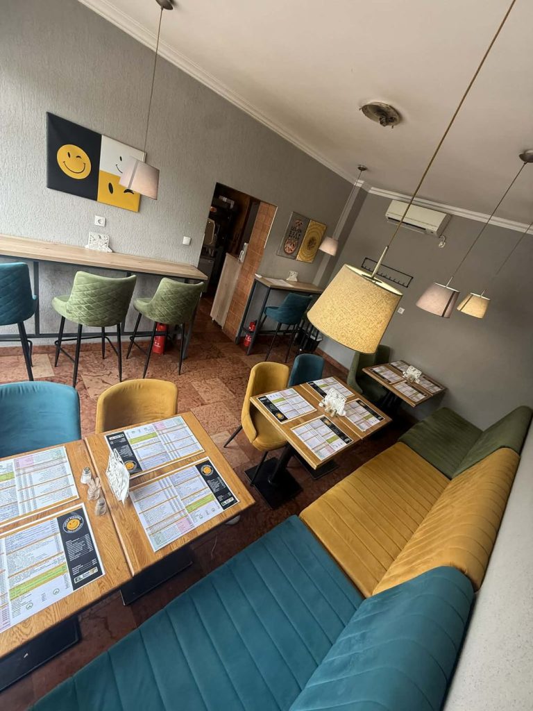 A Kálvária téri Lucky Pizzéria vendégtere zöld és mustársárga ülésekkel